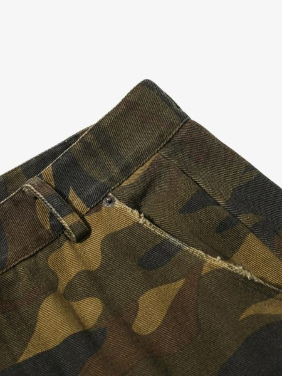 Close-up of camouflage fabric with a visible stitching detail on a white background
