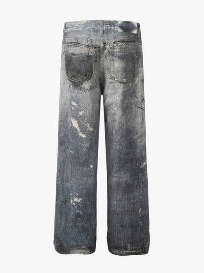Distressed heavy-duty painted straight-leg jeans, adorned with red graffiti prints and paint-splatter wash effects?